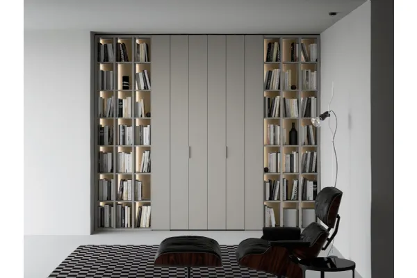Libreria a giorno lineare e geometrica, in laccato opaco, arricchita dalla schiena in laccato metallico Oxid e impreziosita dall’illuminazione a led passaggio porta di Caccaro