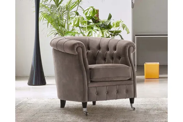 Poltroncina in pelle vintage trapuntata con piedini posteriori in legno e anteriori in legno e ruote cromate SABRINA di Rosini Divani